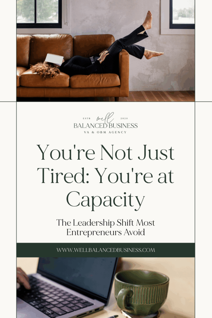 Overwhelmed entrepreneur lying on tan leather couch with laptop and notebook, representing business owner burnout and capacity overload